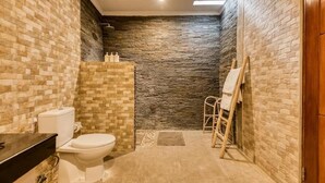 A bathroom with a toilet, a sink, and a shower area. - Villa Dion Bali (Badung)