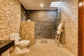 Ein Badezimmer mit Toilette, Waschbecken und Duschbereich.