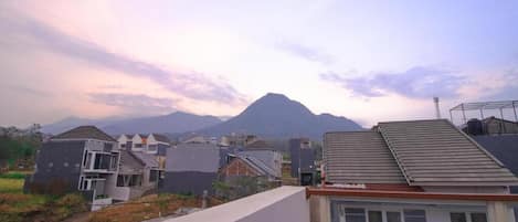 Un barrio residencial con casas modernas, una montaña al fondo y cielo despejado.