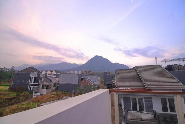 Un barrio residencial con casas modernas, una montaña al fondo y cielo despejado.