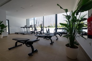 A gym with exercise equipment, a bench, and potted plants. - Luxury 2-Bedroom Apartment with Ocean View in Marbella, Altos de los Monteros (Marbella)