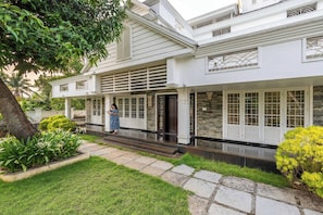 A two-story house with a covered porch, stone steps, and a well-maintained lawn. - Family Friendly Private Pool Villa, Kochi Near Kadamakudi and Lulu (Varapuzha)