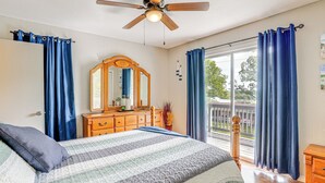 A bedroom with a bed, a dresser, a ceiling fan, and a view of the outdoors. - 1 Mi to Table Rock Lake! Home w/ Water Views (Shell Knob)