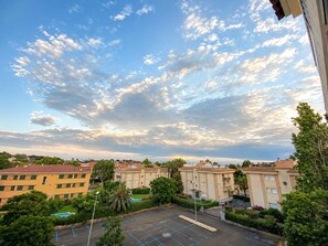 A residential area with multiple apartment buildings, a parking lot, and a clear sky with clouds. - Winahost Piso Gavines (CASTELL-PLATJA D'ARO)