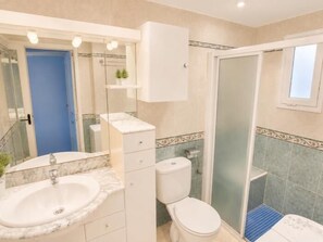 A bathroom with a sink, toilet, and shower area. - Winahost Piso Gavines (CASTELL-PLATJA D'ARO)