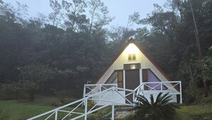 A small, triangular-roofed building with a white staircase leading to a door, surrounded by greenery. - Tranquil Cabin Getaway in San Ramón, Costa Rica (San Ramón)