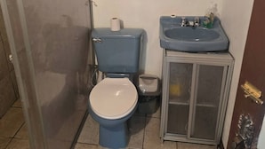 A small bathroom with a toilet, a sink, and a cabinet. - private and pleasant (zapotal)