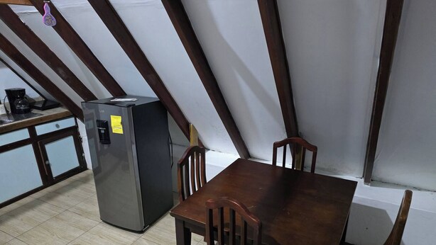 A dining area with a table and chairs, a refrigerator, and a coffee maker. - private and pleasant (zapotal)