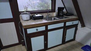 A compact kitchen with a sink, a coffee maker, and a window overlooking greenery. - private and pleasant (zapotal)