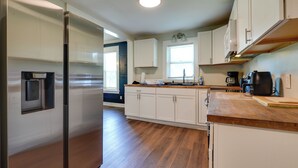 A modern kitchen with white cabinets, a stainless steel refrigerator, wooden countertops, and a built-in microwave. - 1 Mi to UNCG & Dtwn! Group Retreat w/ Private Yard (Greensboro)