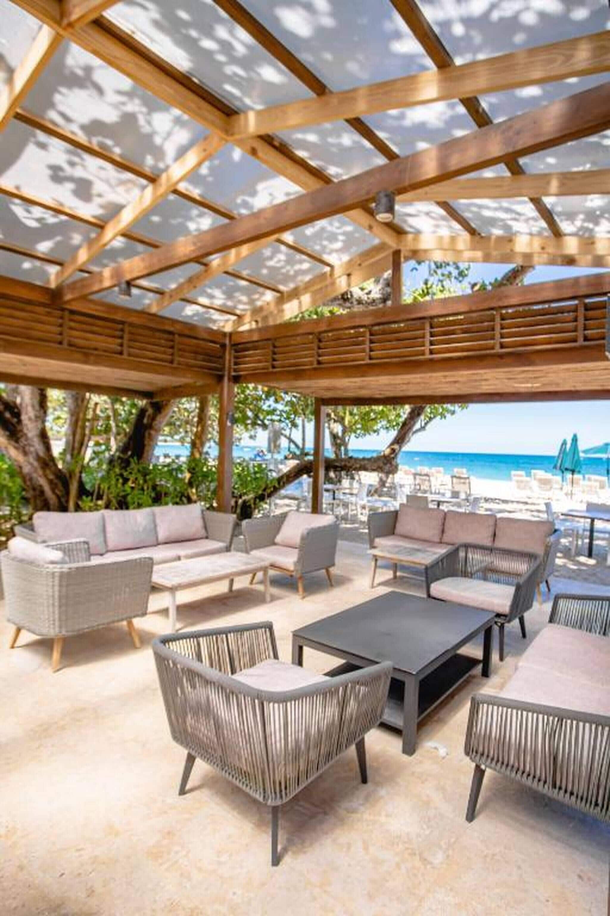 An outdoor seating area with wicker furniture and a view of the sea.