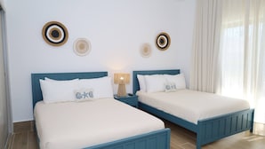 Kamer met een tweepersoonsbed, twee nachtkastjes, een lamp en decoratieve wandkunst.