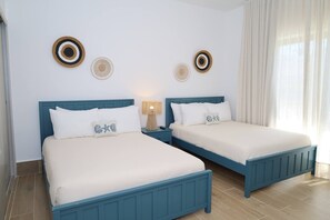 A double bed room with two nightstands, a lamp, and decorative wall art. - Soreli•Peaceful Retreat at Green One Playa Dorada (Puerto Plata city)