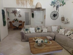 A living room with a sofa, coffee table, and a dining area with a table and chairs. - Exceptional, charming home with a private and exclusive pool (La Motte)