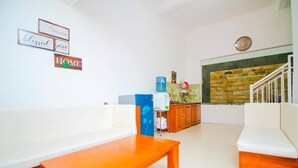Ein Wohnzimmer mit einem weißen Sofa, einem Holztisch und einer Treppe zur Steinwand.