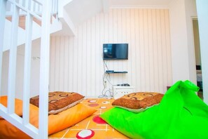 A room with a bunk bed, a television mounted on the wall, and a power outlet. - Cozzy Villa Andela (batu)
