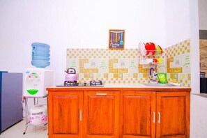 A kitchen with a water dispenser, a kettle, and a sink. - Cozzy Villa Andela (batu)