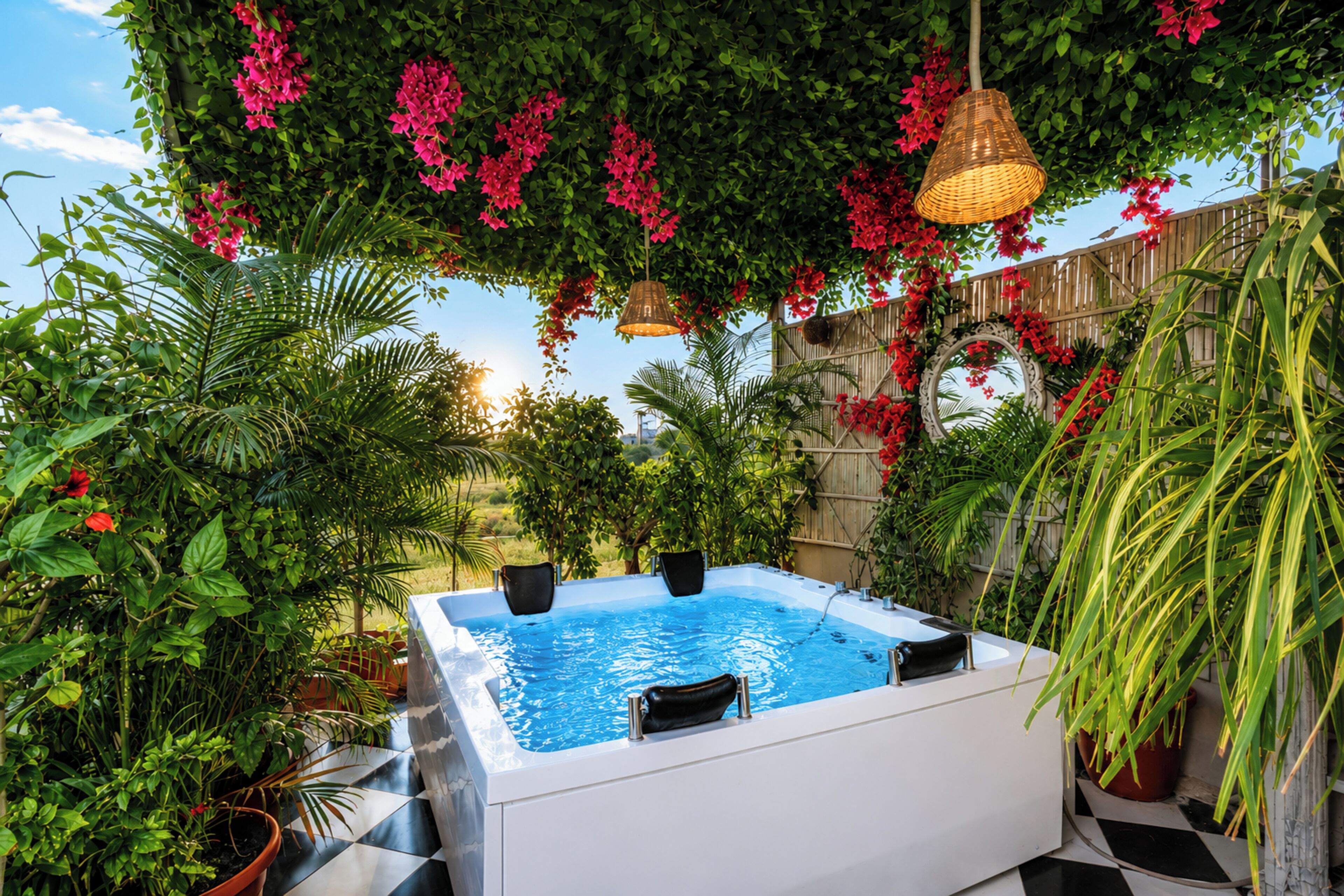 A hot tub surrounded by lush greenery and a wooden fence.