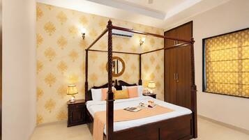 A four-poster bed with a wooden frame, a nightstand with a lamp, and a large mirror on the wall.