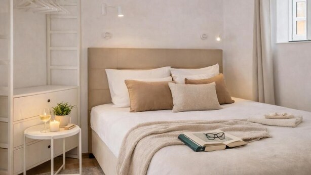 A bedroom with a bed, bedside table, and a nightstand. - Casa Alfama Apartment (Lisboa)