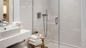 A modern bathroom with a glass-enclosed shower, a white sink, and a toilet. - Praça do Comércio Romantic Apartment (Lisboa)