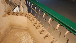 A staircase with a green handrail and metal balusters leading to an upper level.