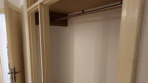 A room with a partially constructed wall, a door, and a tiled floor.