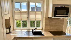 Een moderne keuken met een ingebouwde oven, een kookplaat en een spoelbak.