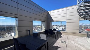 A modern outdoor terrace with a panoramic city view, featuring a dining area with tables and chairs. - Nordic Home Bliss with Sports (Helsinki)