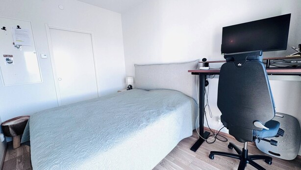 A hotel room with a bed, a desk with a computer, and a chair. - Nordic Home Bliss with Sports (Helsinki)