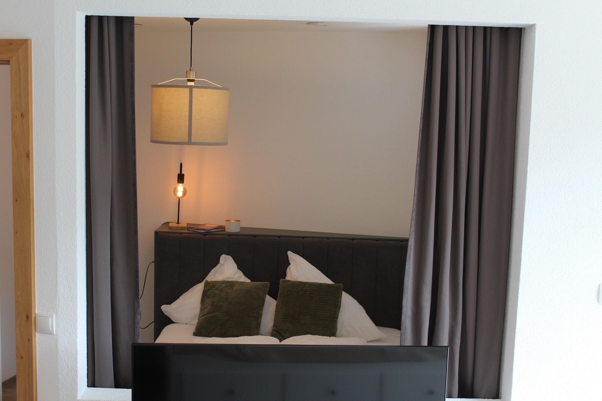Quarto com uma cama, mesa de cabeceira e cabeceira.