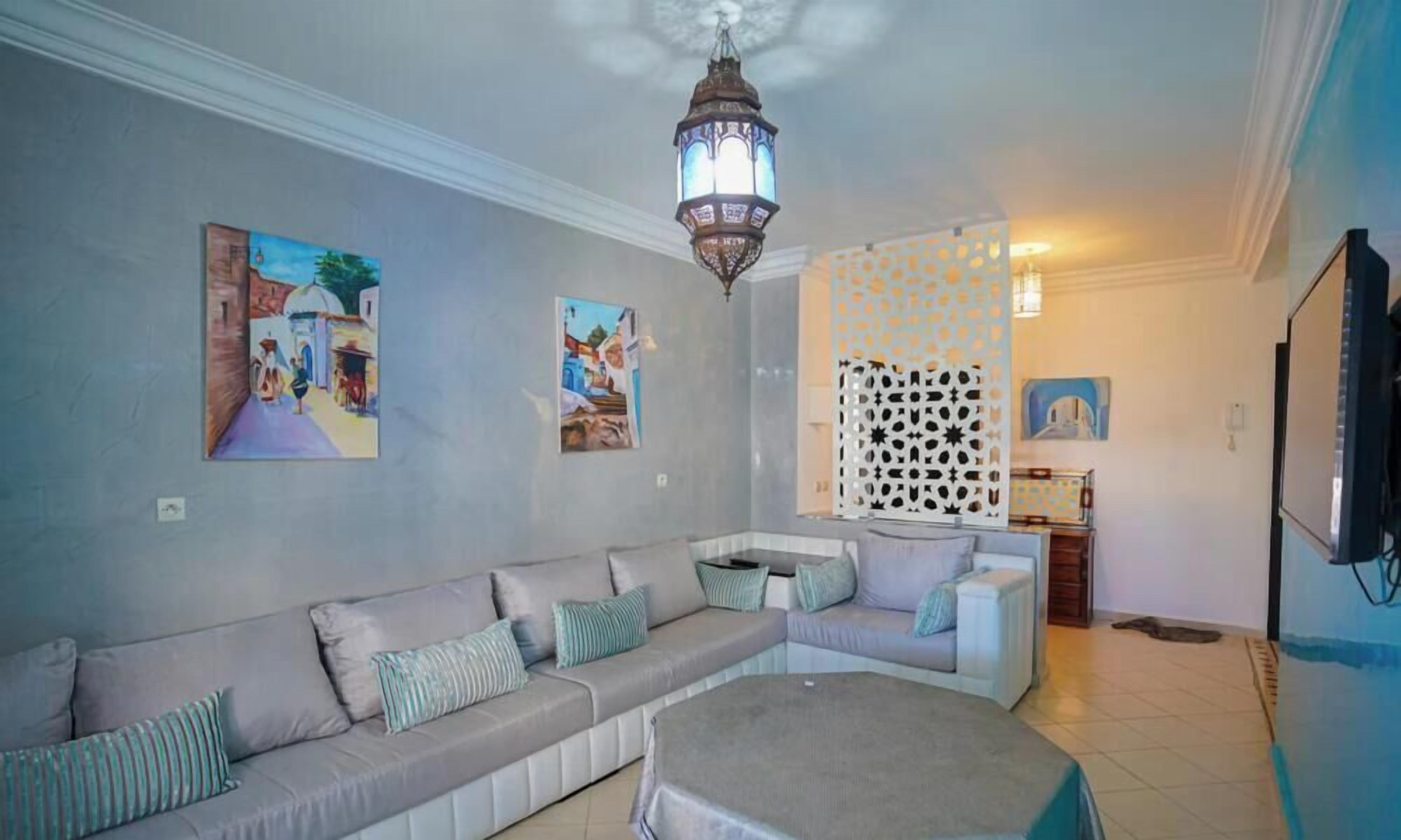 A living room with a sofa, a round coffee table, and a decorative lantern.