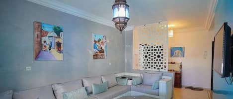 A living room with a sofa, a round coffee table, and a decorative lantern.