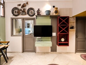 Uma sala de estar moderna com uma TV na parede, uma estante vermelha e uma decoração de motocicleta na parede.
