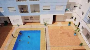 Pátio com piscina rodeado por edifícios.