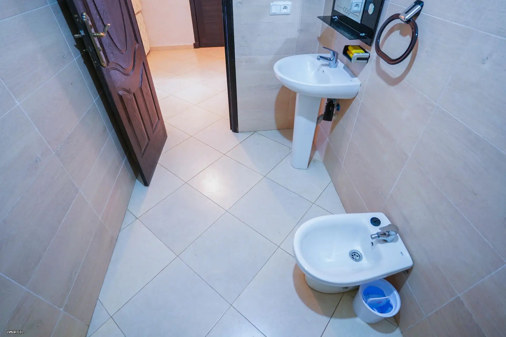 A bathroom with a toilet, bidet, and sink.