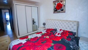 Quarto com uma cama grande, um guarda-roupa, um espelho e um quadro na parede.