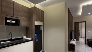 Une cuisine moderne dotée d’appareils électroménagers intégrés, d’un plan de travail noir et d’un design épuré.