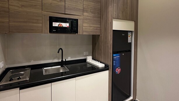 Une cuisine moderne équipée d’un four à micro-ondes, d’une cuisinière, d’un évier et d’un réfrigérateur.