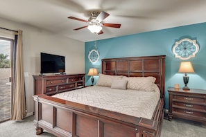 A bedroom with a wooden bed, a ceiling fan, a television, and decorative wall art. - 2 Mi to Lake Havasu! Family Home w/ Poolside Oasis (Lake Havasu City)