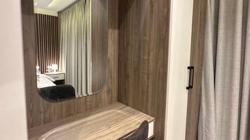 Una camera da letto con una toeletta in legno, uno specchio, una scrivania e un armadio.