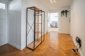 Ein Flur mit einem Metallschrank, Holzboden und einer Tür zu einem anderen Zimmer.
