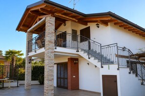 Ein zweistöckiges Haus mit Balkon, Treppe und einer Tür.