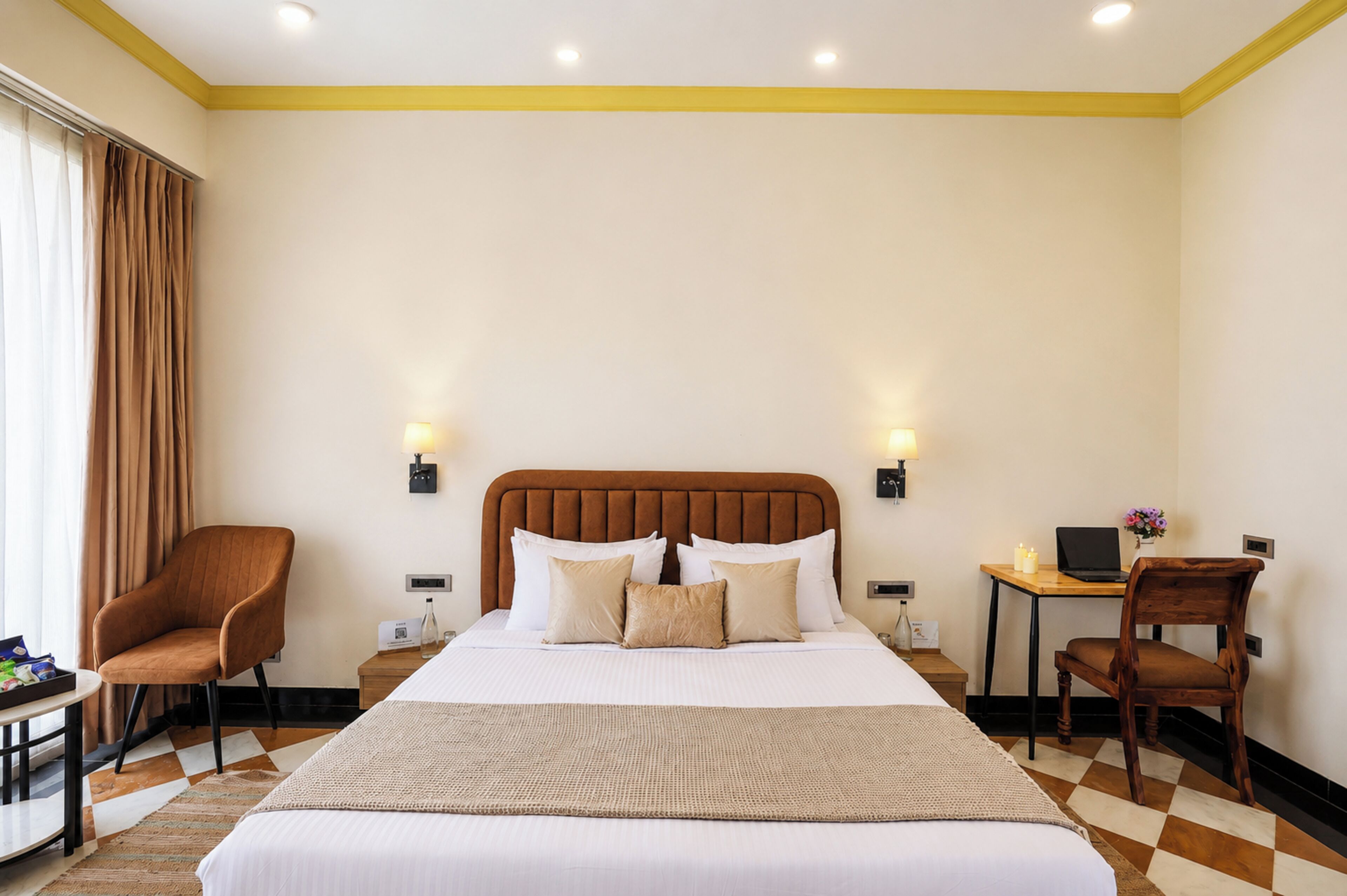 Habitación de hotel con una cama grande, dos mesitas de noche, un escritorio con silla, y una ventana con cortinas.