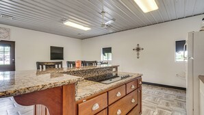 A kitchen with a granite countertop, wooden cabinets, and a built-in stove. - Montrose Studio Getaway w/ Covered Patio (Montrose)