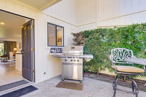 A patio with a stainless steel grill, a white chair, and a door leading to an interior space. - Patios & Golf Course Views: Silverado Resort Condo (Napa)