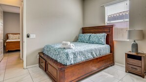 A bedroom with a wooden bed, a nightstand with a lamp, and a window with blinds. - 'Rapt Expression' Queen Creek Home w/ Patio! (Queen Creek)