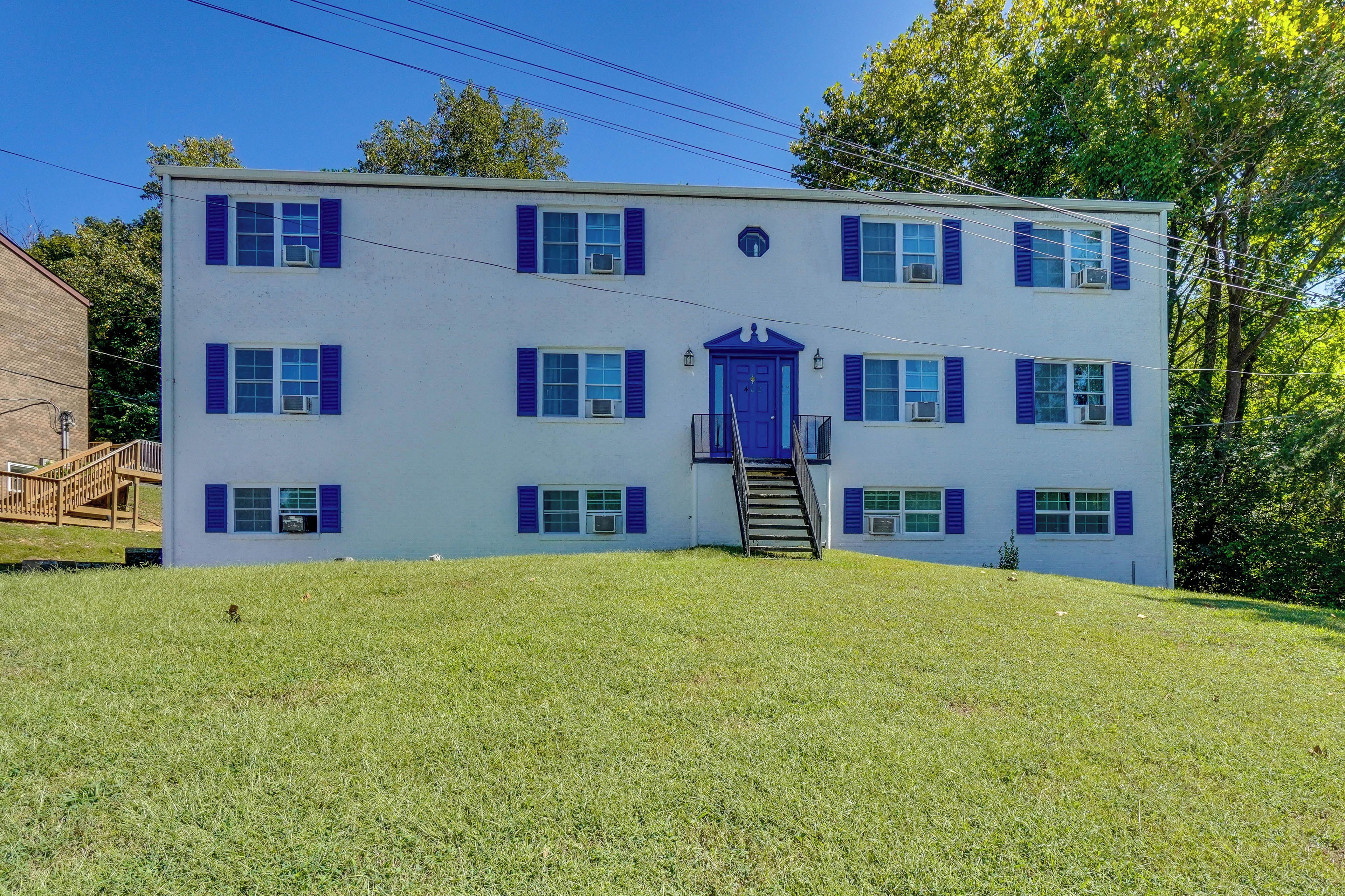 A two-story building with a central entrance and a staircase leading to the upper floor.