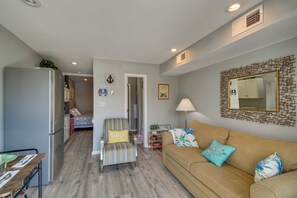 A compact living space with a kitchenette, a sofa, a chair, and a dining table. - Pool, Lake & Sunsets in Front of the Condo Patio (Moneta)