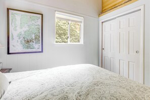 A bedroom with a bed, a window, a door, and a map on the wall. - Lakefront Home w/ Decks & Views in Newbury (Newbury)